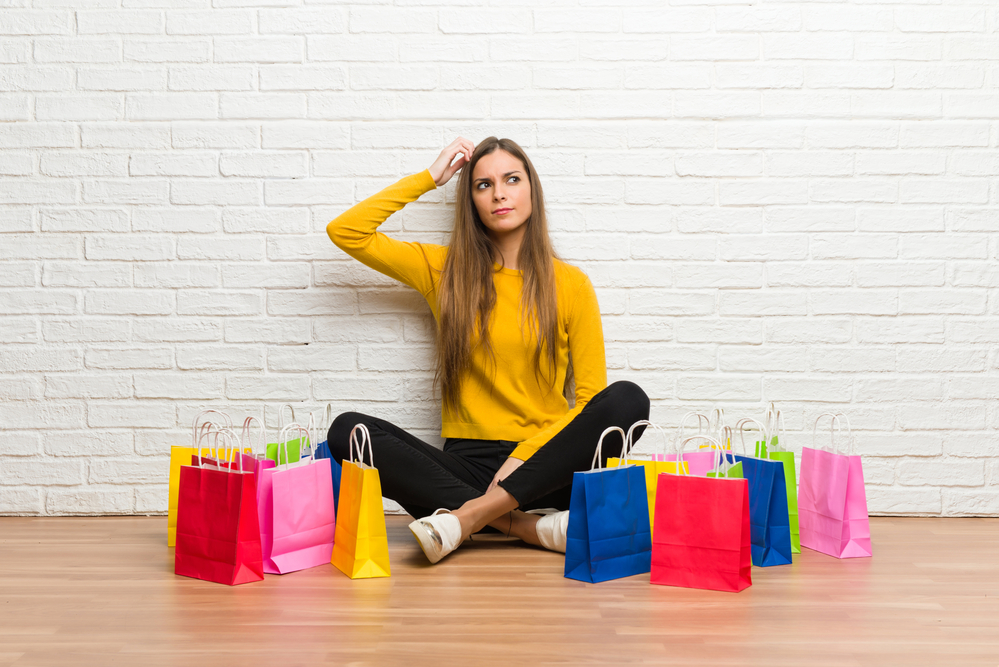 A young woman sitting with multiple shopping bags