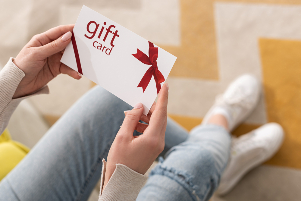 A woman holding a physical gift card