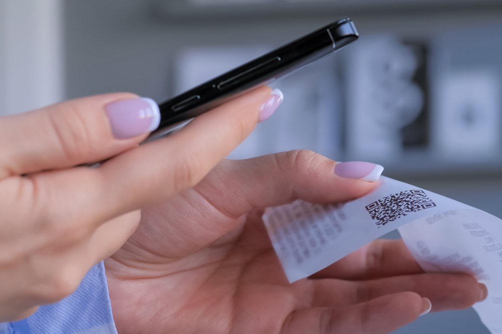 A woman scanning a receipt's QR code using a cellphone