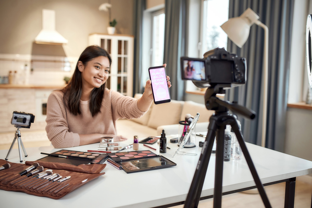 A woman with makeup products filming a video